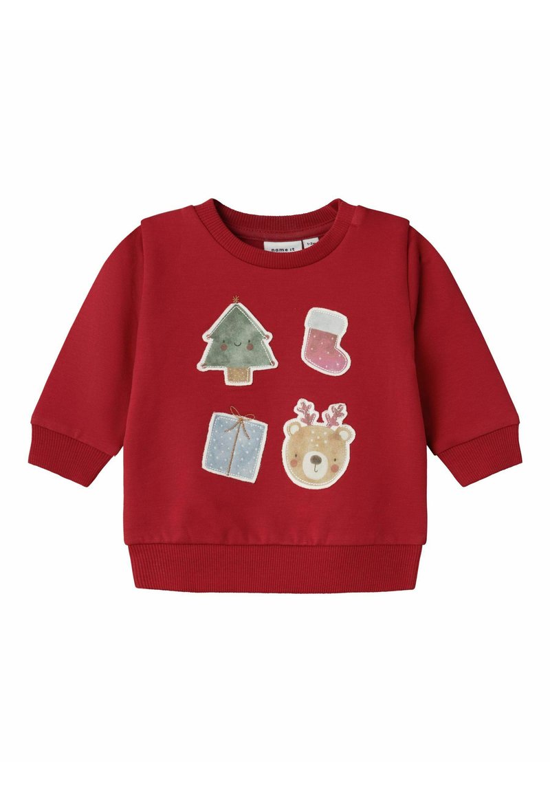 Maglione rosso con polsini e orlo a costine, decorato con applicazioni festive: un albero di Natale, una calza, un regalo e un orsetto.