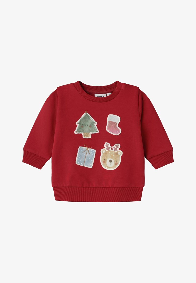 Maglione rosso con polsini e orlo a costine, decorato con applicazioni festive: un albero di Natale, una calza, un regalo e un orsetto.