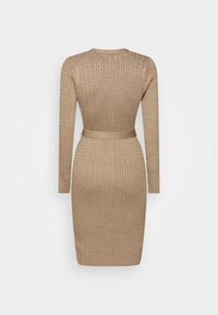 Robe beige en maille torsadée, manches longues, longueur au genou, avec une taille cintrée et une ceinture assortie, vue de dos sur un fond uni.