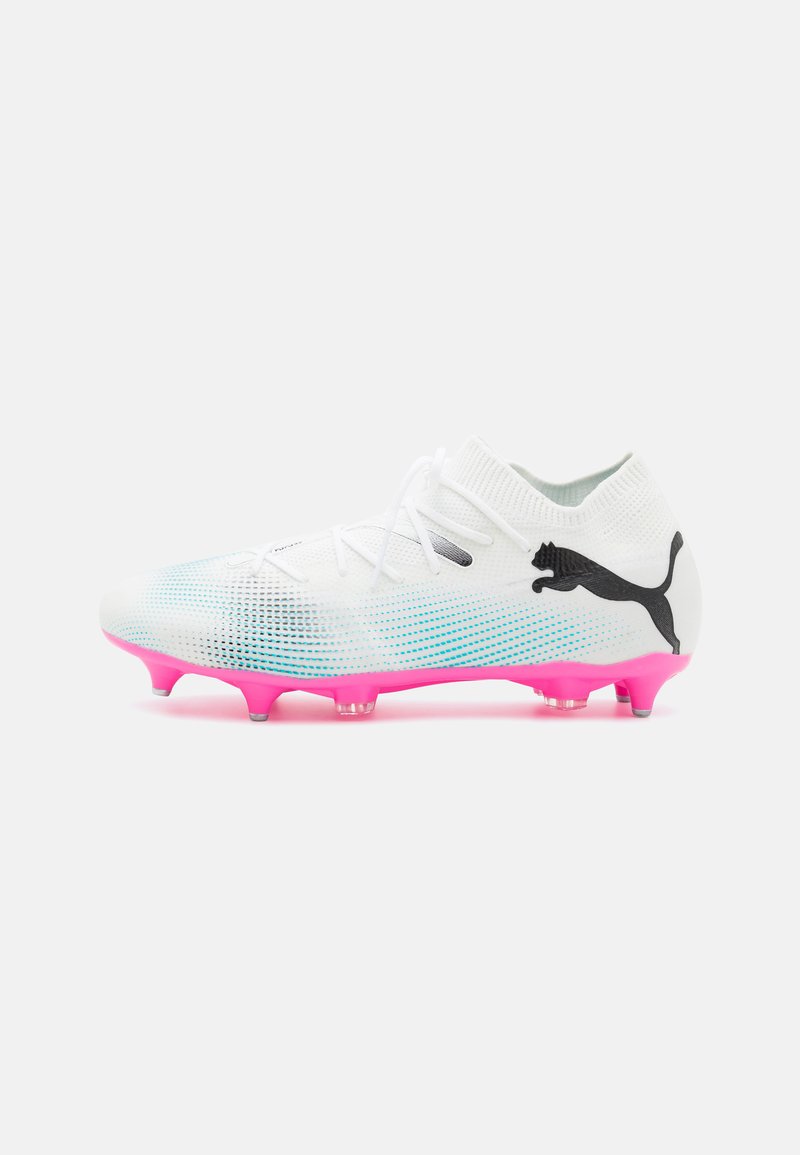 Scarpe da calcio bianche con superficie texturizzata, dettagli in gradi blu, suola traslucida rosa e logo Puma nero sul lato.