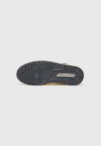 Sorte gummisål på sneakers med teksturerede mønstre og et cirkulært design; har 'JORDAN' branding i hvid nær hælen.