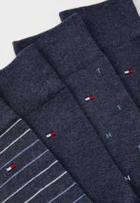 Set di calzini blu navy, con motivi a tinta unita e a righe, caratterizzati da una fine trama a maglia. Ogni calzino presenta un piccolo logo in colori contrastanti.