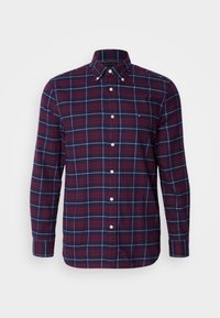 Chemise homme à manches longues boutonnée avec motif à carreaux bleu marine et rouge et boutons blancs, dotée d'un col classique et de manches à poignets.