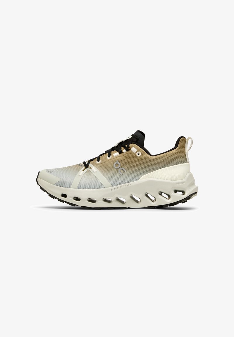 Scarpa da corsa leggera con tomaia in mesh degradé beige a grigio, intersuola bianca, lacci neri e distintivi pod di ammortizzazione sulla suola.