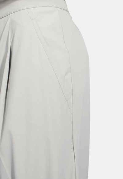 Pantaloni grigi chiari realizzati in tessuto morbido, con un design su misura caratterizzato da cuciture visibili e una vita strutturata. Dettaglio della cucitura laterale incluso.