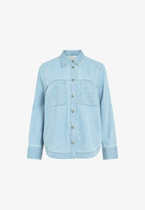 Chemise en denim bleu clair avec boutons, manches longues, deux poches poitrine avant et un motif "R" cousu sur la poche droite.