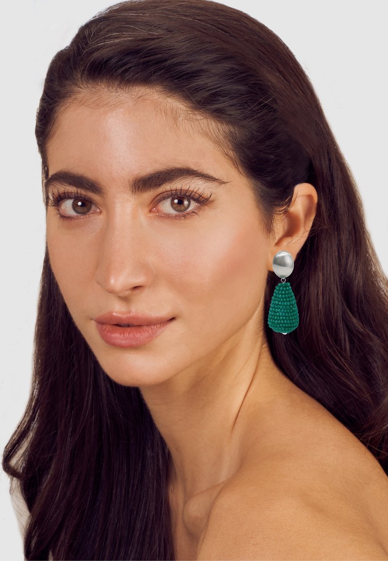 Silver-tone stud earring with a green textured drop, shaped like a teardrop. Smooth surface contrasts with the raised details of the drop.