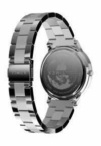 Montre en acier inoxydable avec un bracelet en métal poli, présentant un boîtier circulaire et un logo gravé sur le fermoir, mettant en avant un design arrière détaillé.