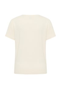 Kremowa koszulka z krótkim rękawem o okrągłym dekolcie i miękkiej bawełnianej fakturze. Widok z tyłu pokazuje czysty design bez zdobień.