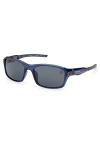 Gafas de sol rectangulares de color azul marino con lentes grises, fabricadas con plástico ecológico. Presentan un marco grueso y una sutil marca en el lateral.