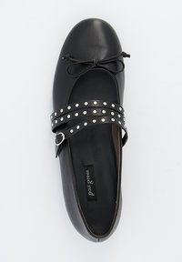Bailarinas de cuero negro con punta redonda y correa decorativa de hebilla con tachuelas plateadas. Textura suave con un diseño minimalista.