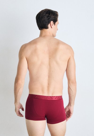 Boxeri burgundy cu un brâu elastic texturat, evidențiind un design ajustat și un material neted. Văzuți din spate.