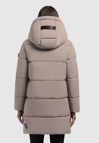 Abrigo largo acolchado en gris claro con cuello alto, que cuenta con una capucha con cremallera, secciones acolchadas horizontales y una etiqueta de logo en la parte trasera.