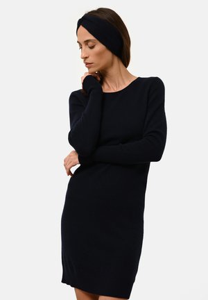 Robe en tricot bleu marine à manches longues et poignets côtelés, avec un décolleté bateau et une silhouette ajustée, accompagnée d'un bandeau assorti.
