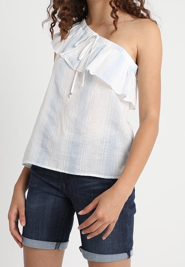 Top asymétrique blanc et bleu clair à rayures avec un décolleté volanté et un cordon de serrage. Associé à un short en denim noir, retroussé au niveau de l'ourlet.