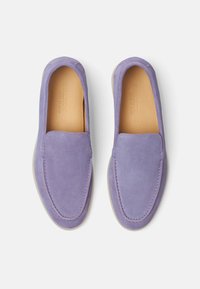 Lilla ruskinds slip-on sko med en rund tå, polstret inderside og en tekstureret sål. Har et enkelt syet detalje langs kanterne.