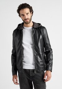 Svart läderjacka med grå huva, utrustad med dragkedja fram, sidofickor och en figurnära design. Texturen är slät med en modern silhuett.