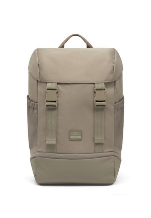 Beige rectangular backpack with top handle, two front buckle straps, side pockets, and a logo patch labeled "Johnny Urban."