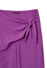 Jupe enroulée violette avec un design noué à la taille. Fabriquée en tissu léger avec une texture douce et un léger tombé.