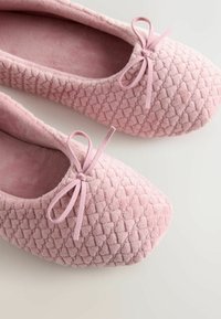 Mocassini da balletto rosa tenue con design trapuntato e testurizzato. Presentano un fiocco decorativo rosa abbinato sul davanti. Solette imbottite.