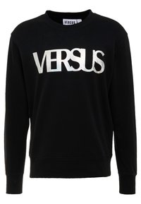 Sudadera de algodón negra con un logo metálico plateado "VERSUS" en el frente, cuello redondo y mangas largas con puños de canalé.