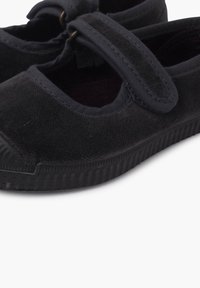 Scarpe Mary Jane in tela nera con chiusura a cinturino e un piccolo dettaglio dorato, tessuto texturizzato e suola in gomma robusta.