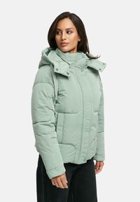 Padded mint green jacket with a high collar, adjustable hood, front pockets, and a smooth, glossy texture, shown on a model.
