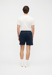 Σορτς σε ναυτικό μπλε χρώμα από απαλό ύφασμα με ελαστική μέση και πίσω τσέπη. Φοριέται με απλή λευκή μπλούζα και λευκές κάλτσες.