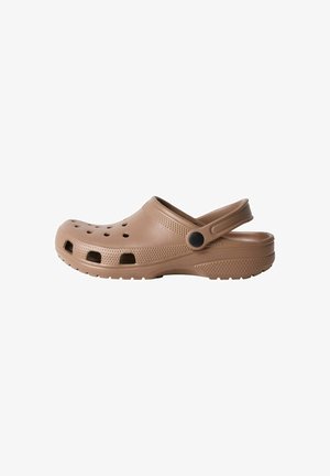 Sabot marron clair à enfiler avec trous de ventilation et bride de talon mobile, semelle texturée et détails antidérapants latéraux.