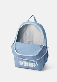 Blauw rugzak met een klepsluiting, lichtgrijze voering, bloemaccenten en een wit logo. Beschikt over een handvat aan de bovenkant en netvakken aan de zijkanten.