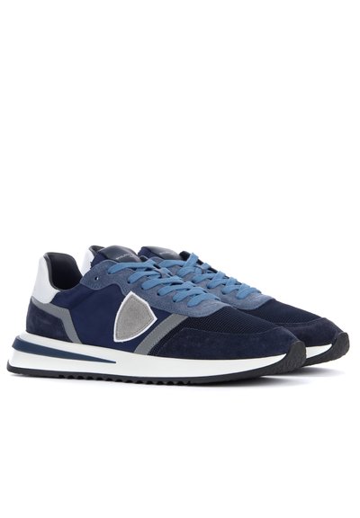 Baskets de sport bleu marine en matériaux suédé et en maille, avec des lacets bleu clair, des accents gris et une semelle intermédiaire blanche avec une semelle extérieure noire texturée.