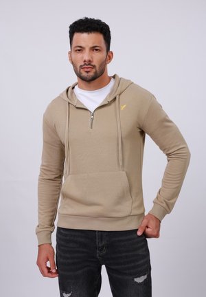 Beige hoodie with a front pocket, long sleeves, and a half-zipper. Features a yellow logo on the chest and ribbed cuffs and hem.