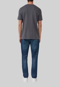 Grijze katoenen t-shirt met korte mouwen, ronde hals, gedragen met blauwe spijkerbroek. Casual ontwerp met een normale pasvorm en een gladde textuur.