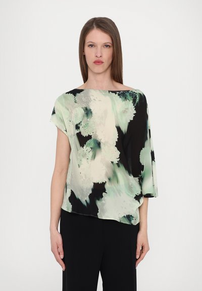Blouse à motifs floraux dans des nuances de vert et de noir, fabriquée en matière légère avec un décolleté bateau et des manches courtes et amples.