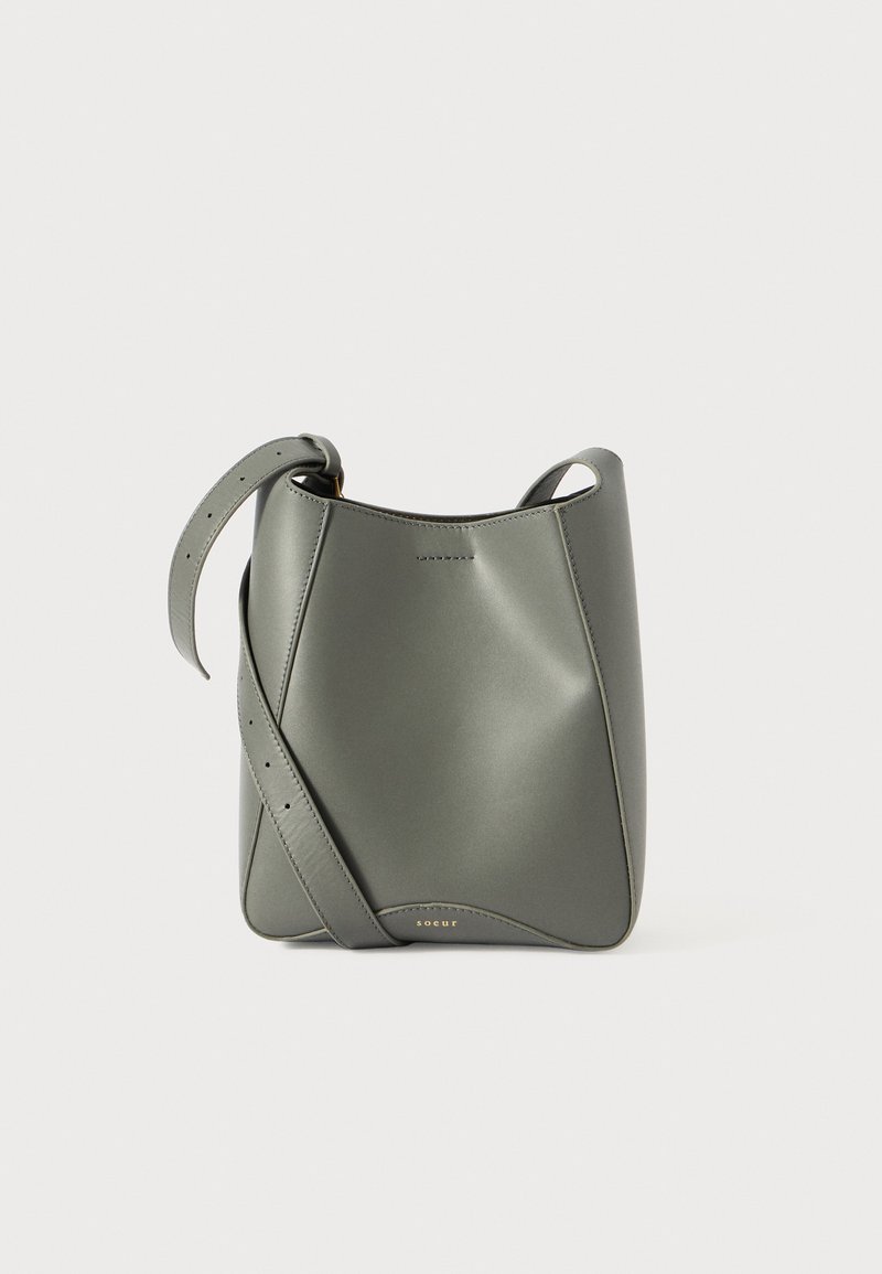 Borsa a secchiello verde in pelle con texture liscia, tracolla regolabile, design geometrico e dettagli minimalisti.