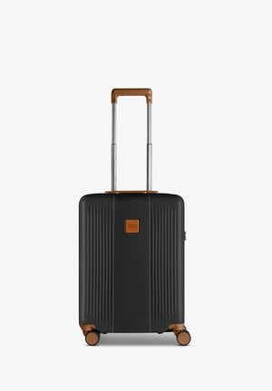 Valigia rigida nera con design a righe, dettagli in marrone, maniglia retrattile e quattro ruote per una facile mobilità. Presenta una patch in pelle con il logo.