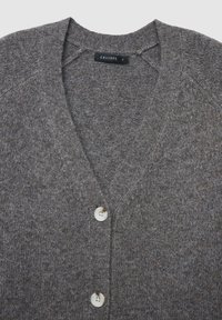 Graue Wollstrickjacke mit V-Ausschnitt und strukturiertem Strickmuster. Drei cremefarbene Knöpfe verlaufen der Mitte entlang. Markenlabel sichtbar.