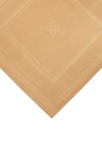 Beżowy materiał o gładkiej teksturze, z wykończeniem w postaci bordiury oraz subtelny wzór monogramu na środku. Kwadratowy kształt, minimalistyczne akcenty.