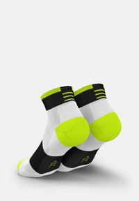 Kurze Sportsocken in Schwarz, Weiß und Neon-Grün; mit gepolsteter Sohle, gestreiftem Rippenbündchen und Logodetail an der Seite.