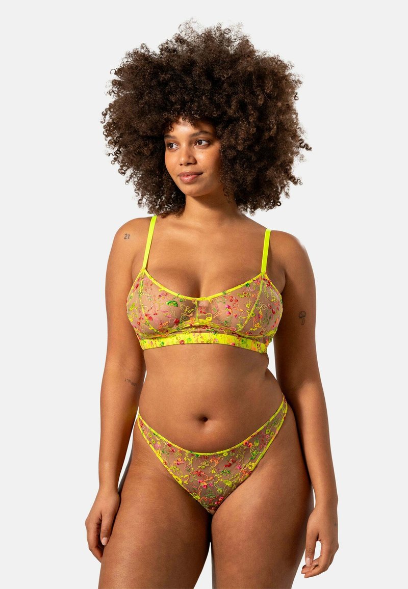 Genomskinlig blommig underklädesset i neongul med intrikata blommönster. Bh:n har justerbara axelremmar; matchande trosor med låg midja.