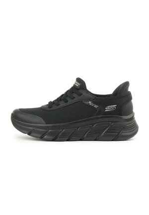 Scarpe sportive nere con tomaia in mesh testurizzato, suola spessa e ammortizzata, e punta rinforzata. Presentano lacci piatti e dettagli del logo sul lato.