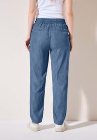 Pantaloni azzurri chiaro, morbidi, con vita elastica, due tasche sul retro e un tessuto liscio e texture. Design casual con polsi cuffi.