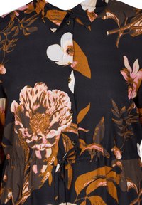 Camicia floreale in tessuto nero con grandi fiori arancioni e rosa, chiusura a bottoni, colletto e cordoncino in vita.