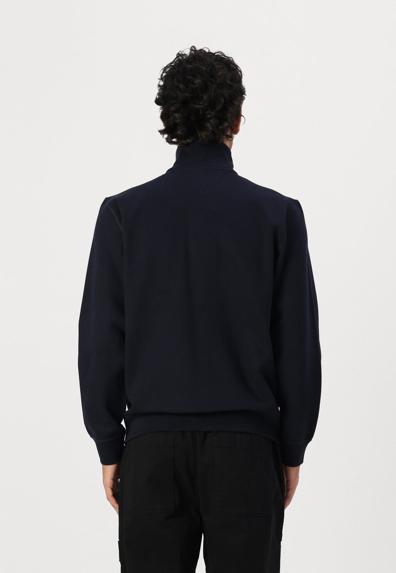 Dunkelblaues Sweatshirt mit hohem Kragen, langen Ärmeln, gerippten Bündchen und Saum. Glatte Textur, minimalistisches Design und keine sichtbaren Muster oder Logos.