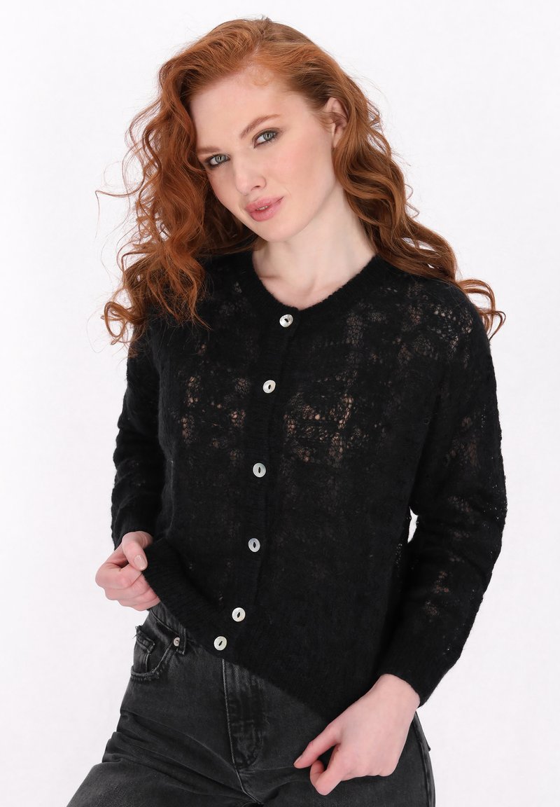 Cardigan nero lavorato a maglia con un motivo in pizzo, scollo rotondo e cinque bottoni lucidi sul davanti. Maniche lunghe con polsini a coste.
