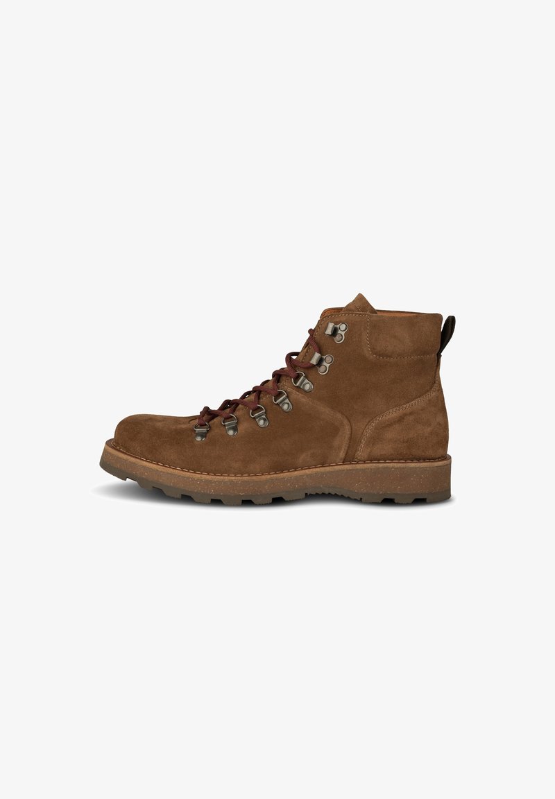 Botte de randonnée en daim marron avec œillets métalliques, lacets marron foncé, cheville retroussée et semelle en caoutchouc robuste, vue de profil.