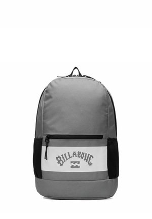 Grijze rugzak met een witte voorvak, zwarte mesh zijvakken en het "Billabong" logo in gestileerde letters op de voorvak.