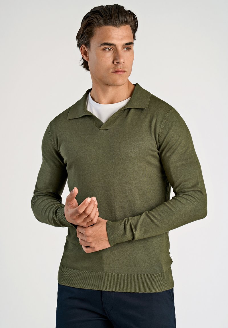 Olivengrüner Strickpullover mit V-Ausschnitt und langen Ärmeln. Das Material ist glatt und hat einen gerippten Saum sowie Manschetten für zusätzliche Textur.