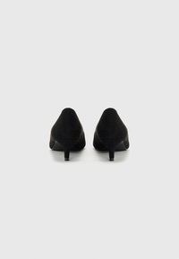 Scarpe con tacco alto in suede nero con punta affusolata e tacco sottile, caratterizzate da una texture liscia e una silhouette pulita.