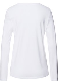 Camisa de manga larga blanca con un cuello redondo, hecha de una suave tela de algodón. La parte trasera es lisa sin costuras ni patrones visibles.